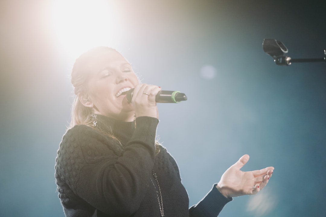 a woman singing into a microphone on stage