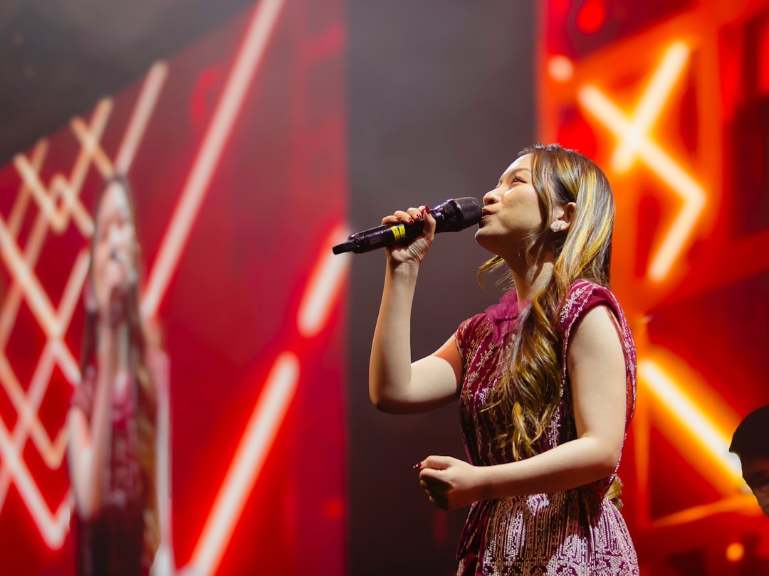 A woman singing into a microphone on stage