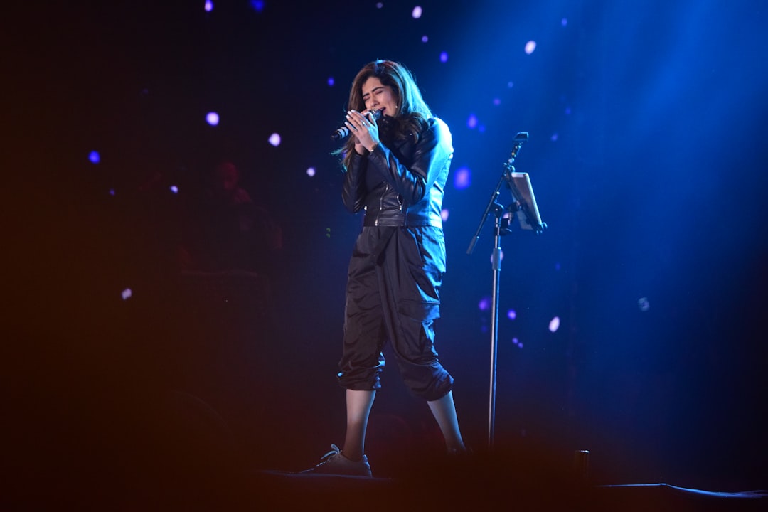 woman in black jacket singing on stage