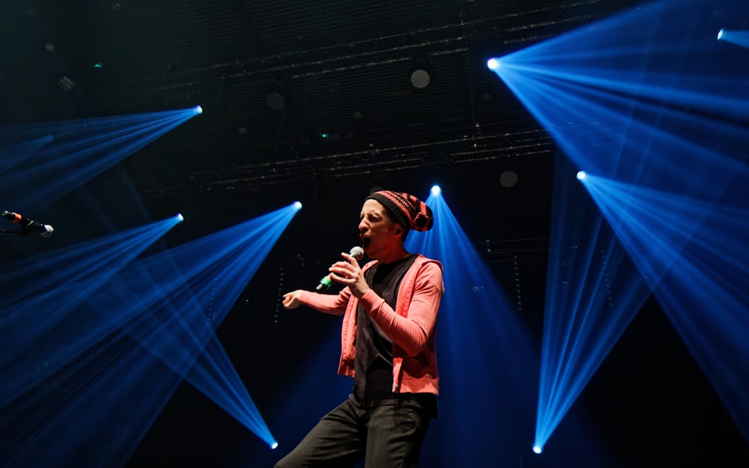 A woman sings on stage with bright lights.