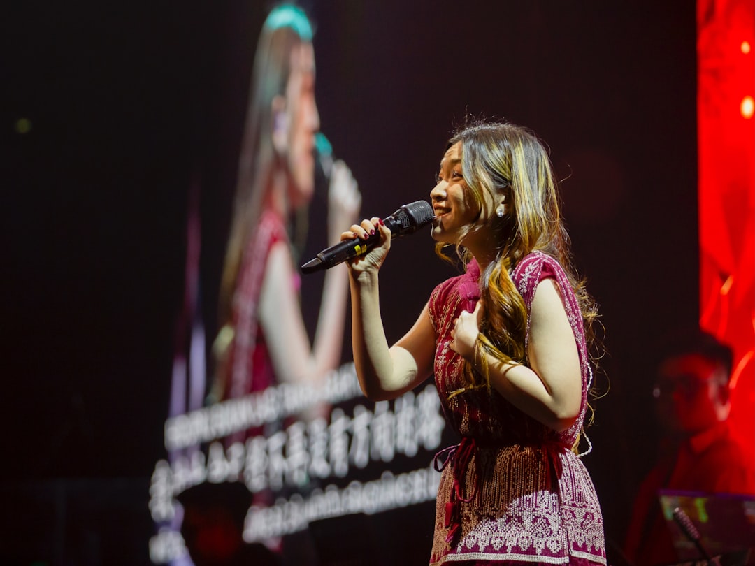 A woman singing into a microphone on stage