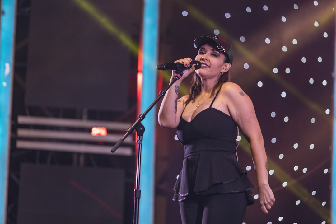 a woman singing into a microphone on stage