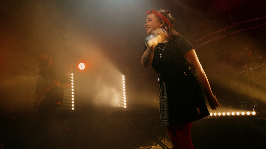 woman in black dress singing on stage