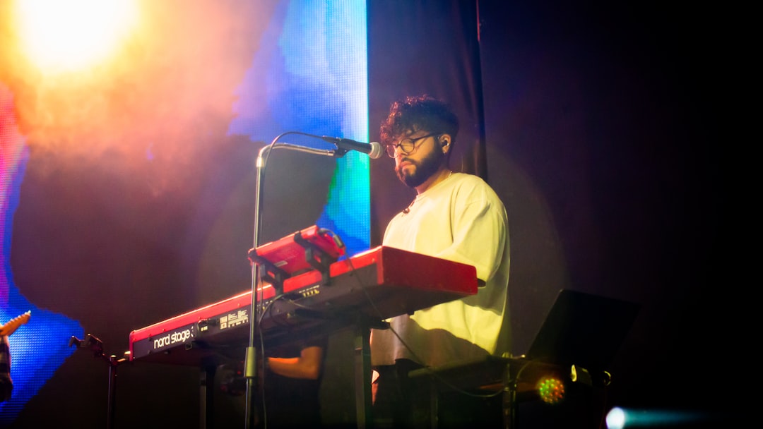 A man standing next to a keyboard on a stage