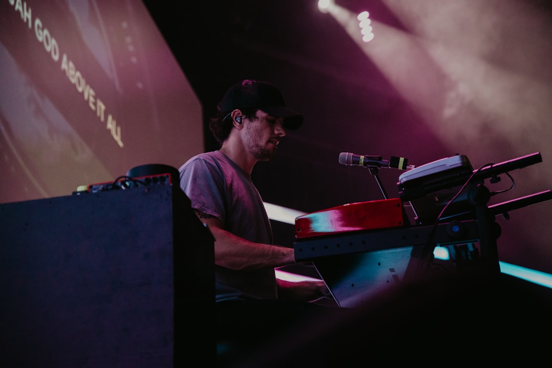 man in white crew neck t-shirt playing red and black dj controller