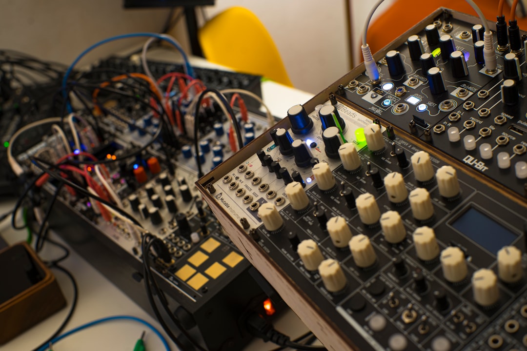 a sound mixing console with many knobs and wires