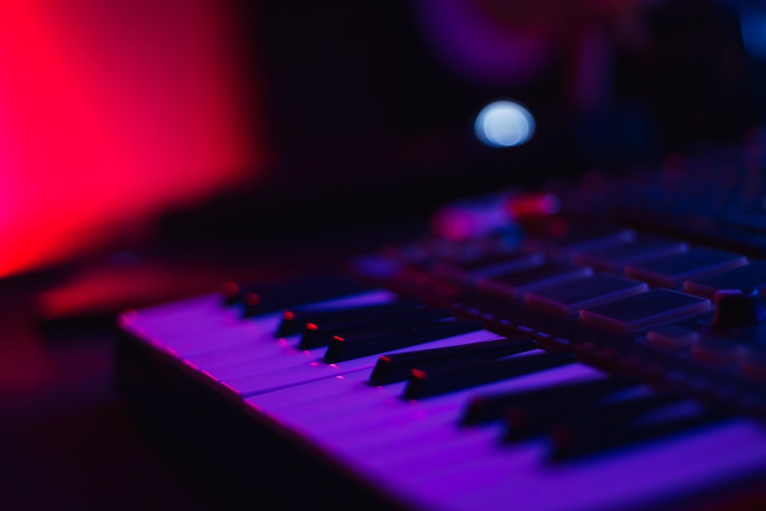 Close-up of a synthesizer keyboard with purple and red lighting